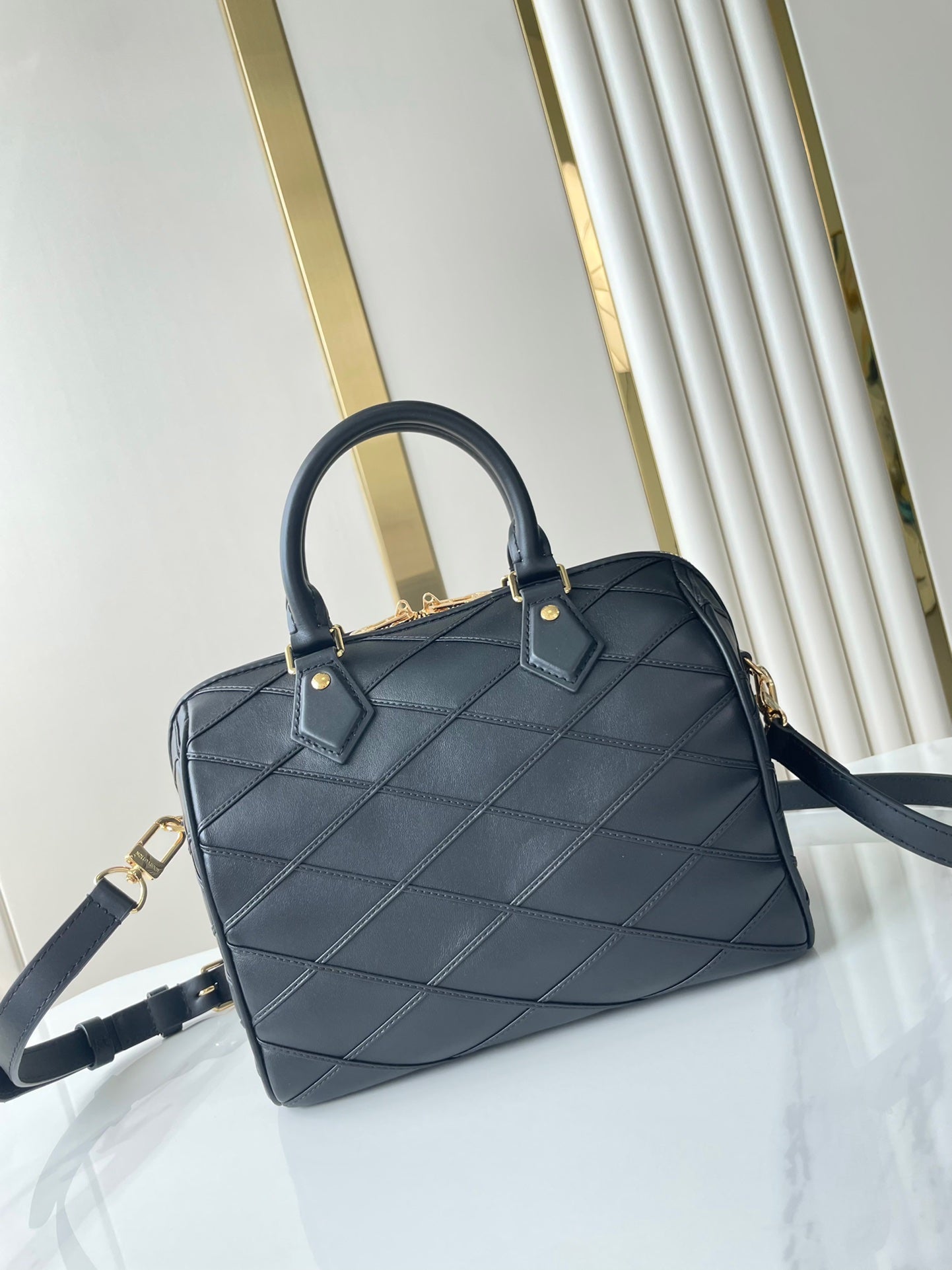 SPEEDY BANDOULIÈRE 25 WITH CRISS CROSS PATTERN IN BLACK LAMBSKIN